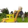 A toddler pushing a yellow toy truck for unfinished doll houses